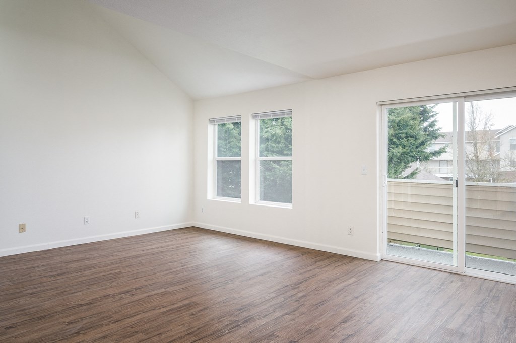 a bedroom with hardwood floors and white walls