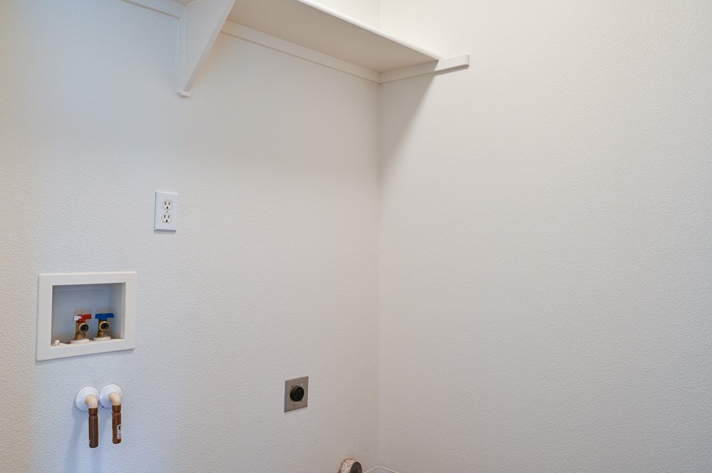 a bathroom with white walls and a white shelf on the wall