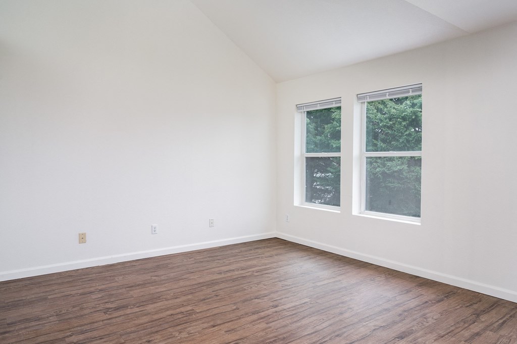 a bedroom with hardwood floors and white walls