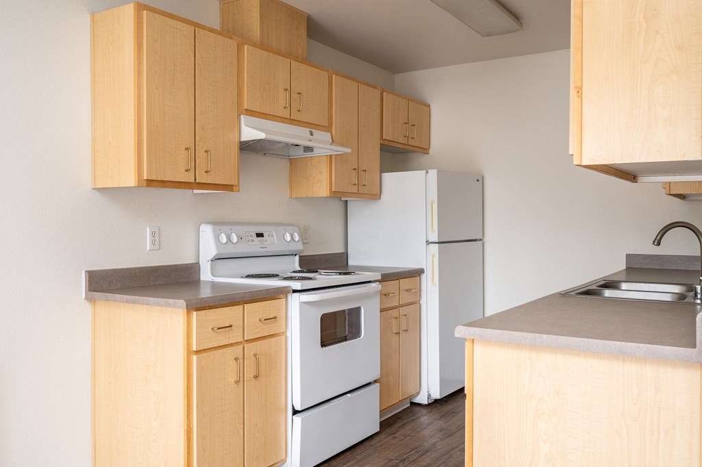 a kitchen with white appliances and wooden cabinets