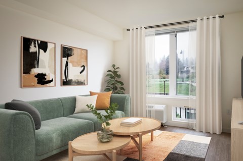 A living room with a green couch, a coffee table, and two abstract paintings on the wall.