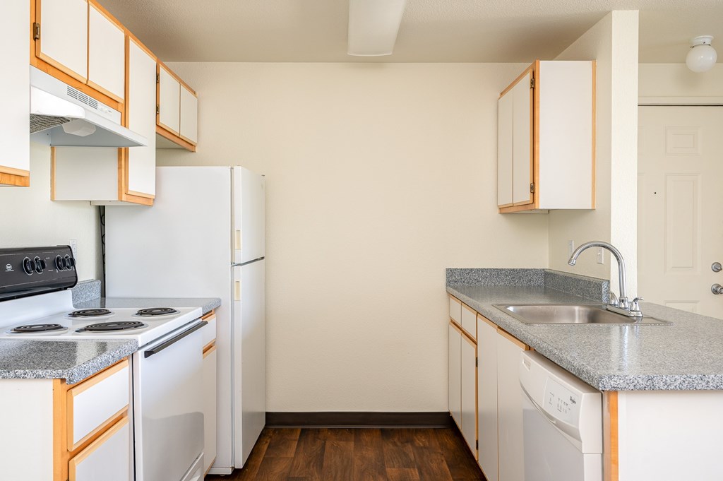 A kitchen with white appliances and wooden cabinets.