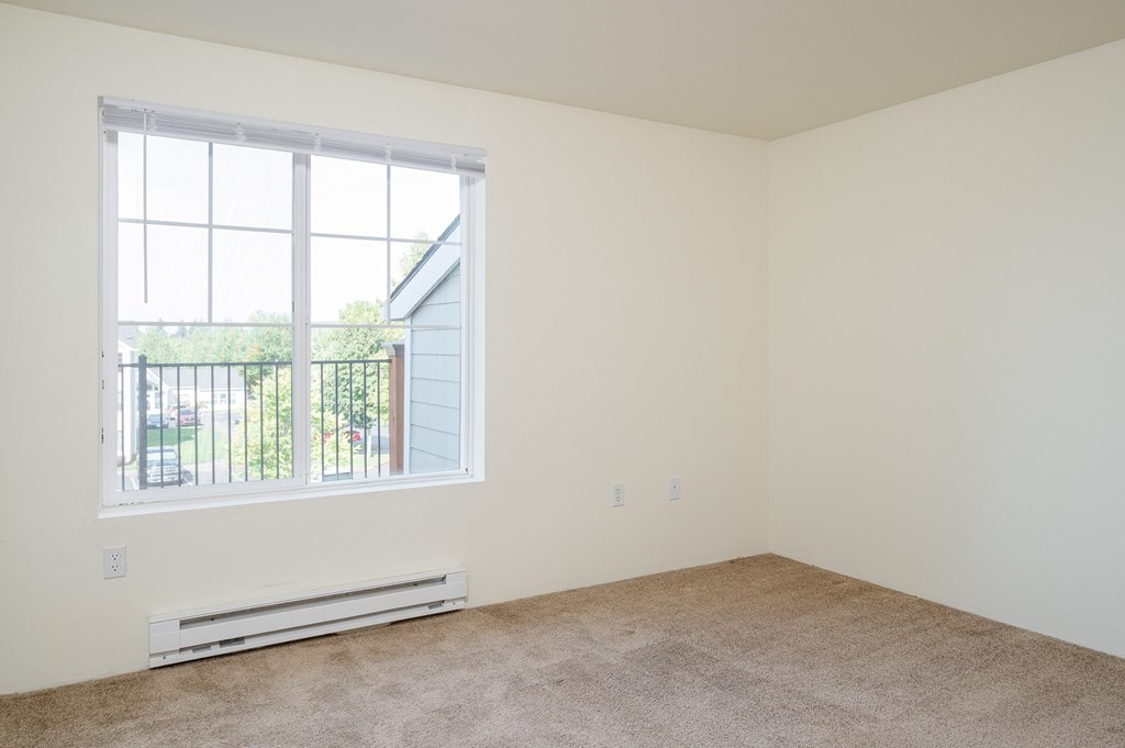 A room with a window and a radiator on the floor.