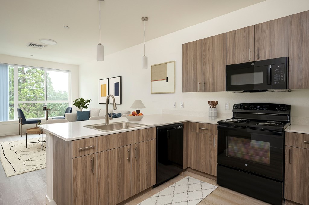 A modern kitchen with wooden cabinets and black appliances.