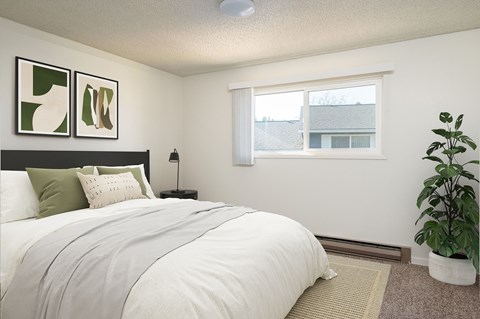 A bedroom with a large bed and a potted plant.