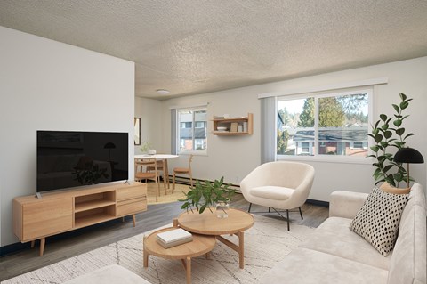 A living room with a white couch, a wooden coffee table, and a flat-screen TV.