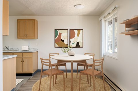 A dining room with a round table and chairs.