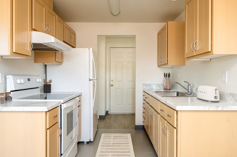 A kitchen with wooden cabinets and a white refrigerator.