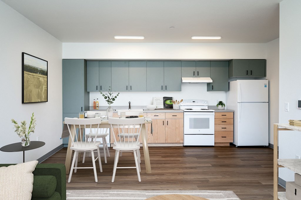 a kitchen with white appliances and a table and chairs