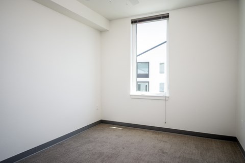 an empty room with a window and a carpet