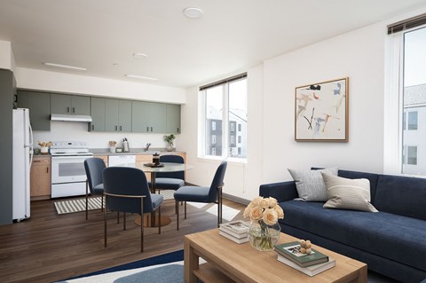 a living room with a blue couch and a kitchen with a table and chairs