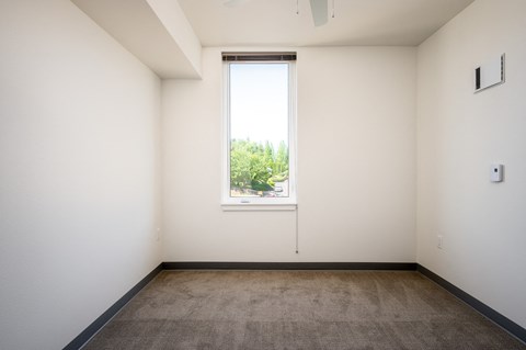 an empty room with a window and a carpet