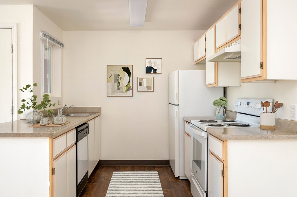 A kitchen with white appliances and wooden cabinets.