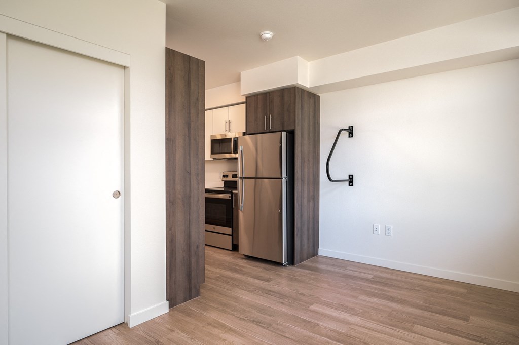 a kitchen with a stainless steel refrigerator in a room with a door