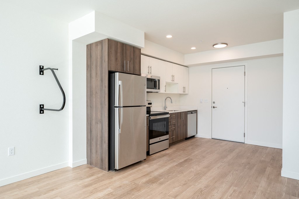 a kitchen with stainless steel appliances and a wood floor