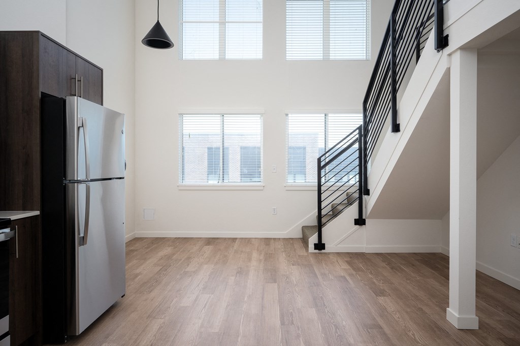 a kitchen with a refrigerator and a staircase in a house