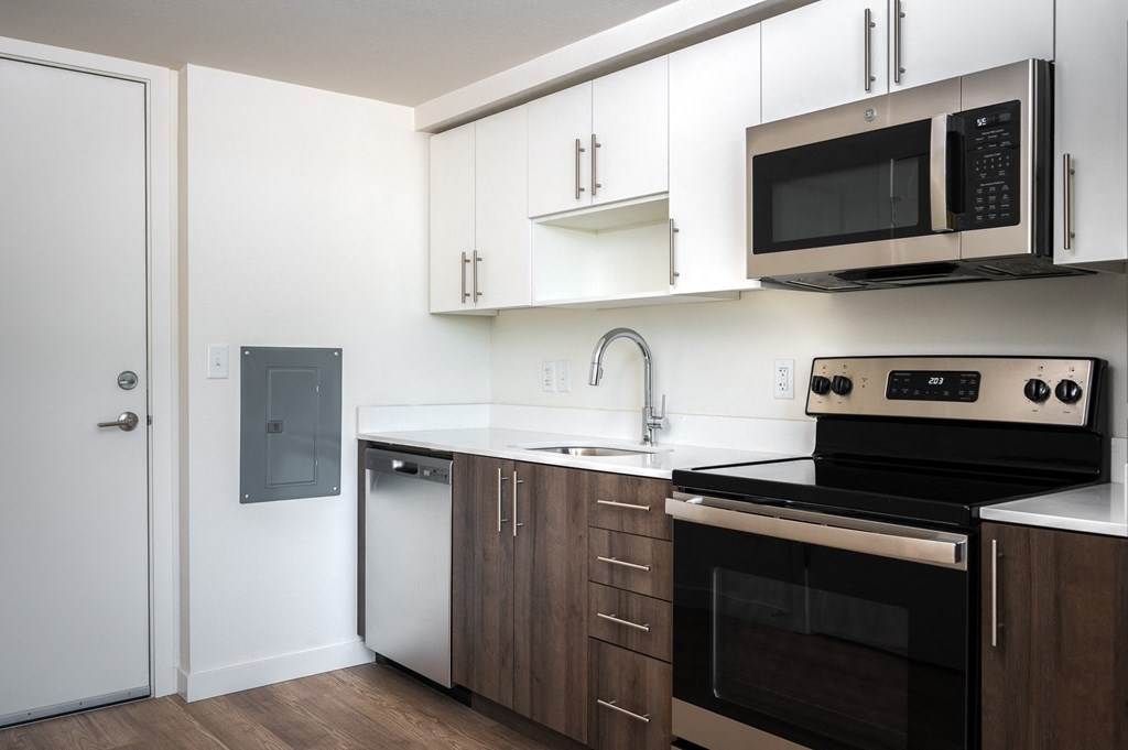 a kitchen with white cabinets and black appliances and a microwave