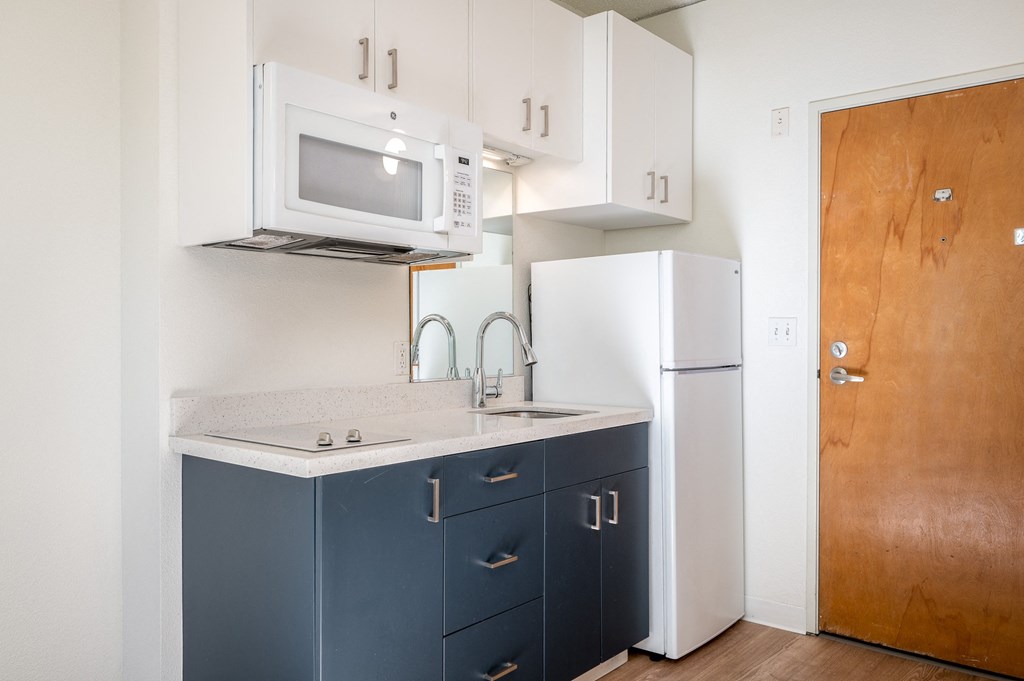 a kitchen with white appliances and blue cabinets