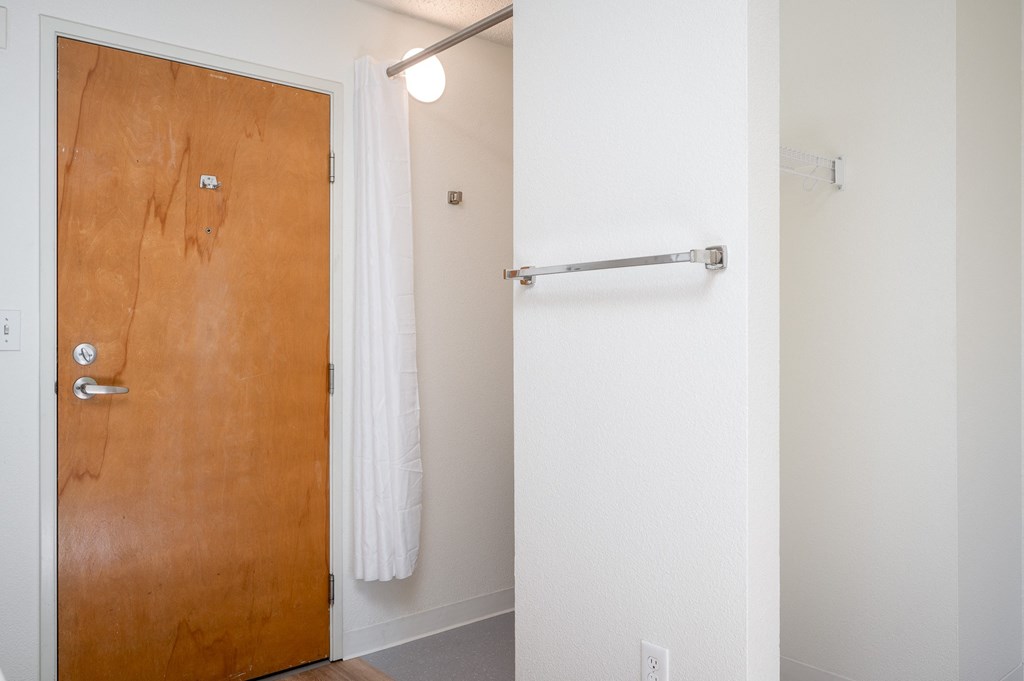 a bathroom with a white shower curtain and a wooden door