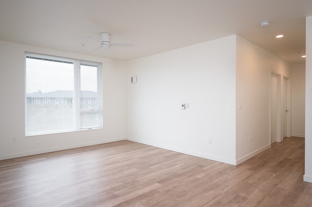 a bedroom with hardwood floors and white walls