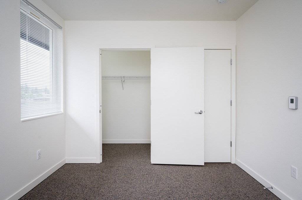 a small bedroom with a closet and a window
