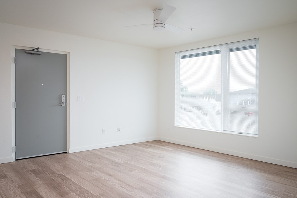 a bedroom with white walls and hardwood floors