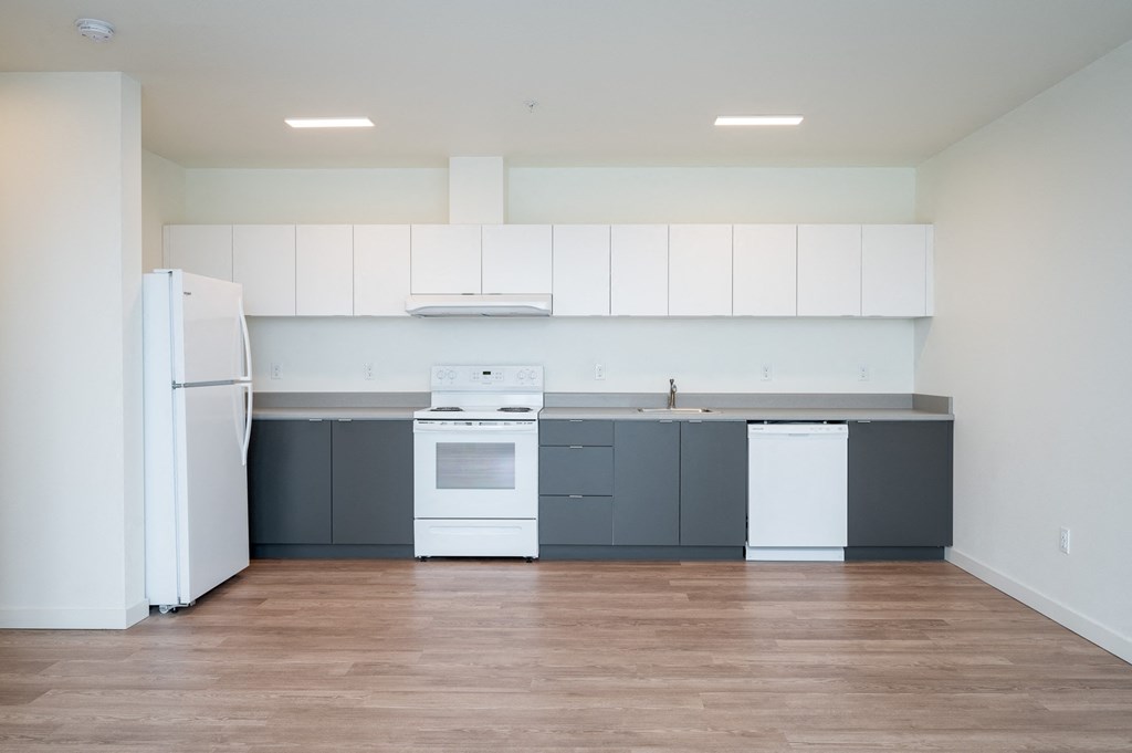 a kitchen with white appliances and gray cabinets