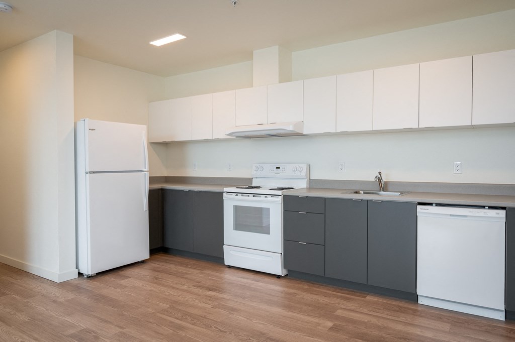 a kitchen with white appliances and gray cabinets