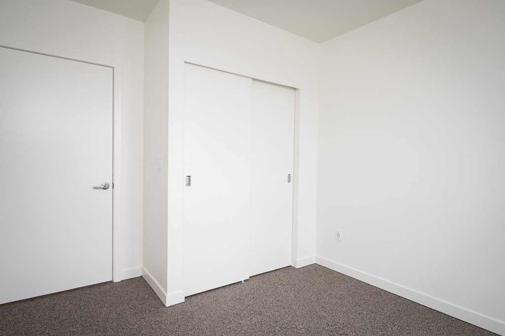 a bedroom with white walls and carpet