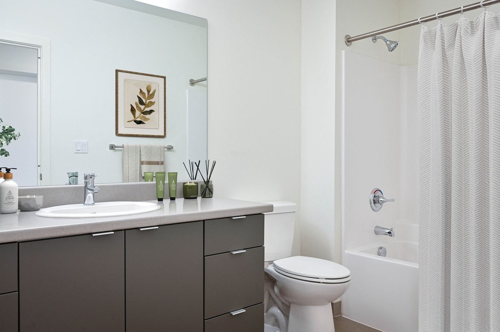 a bathroom with white walls and a white bathtub with a shower curtain