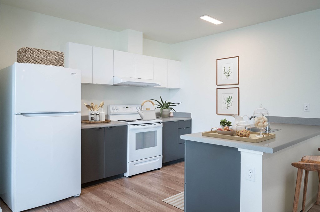 a kitchen with white appliances and gray cabinets