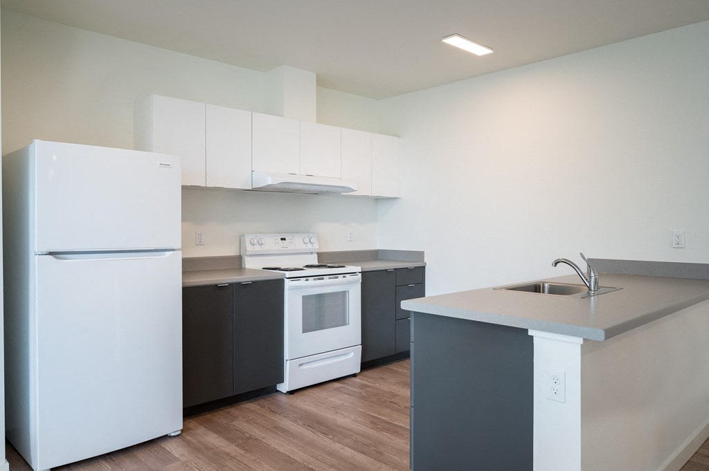 a kitchen with white appliances and gray countertops
