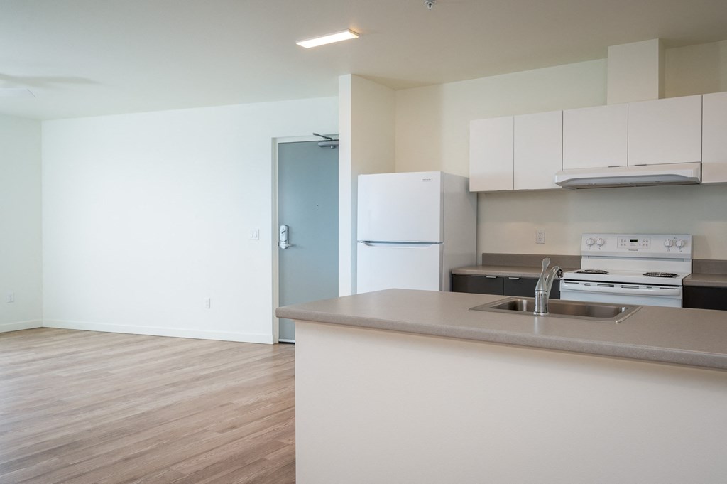 a kitchen with white cabinets and a white stove top oven