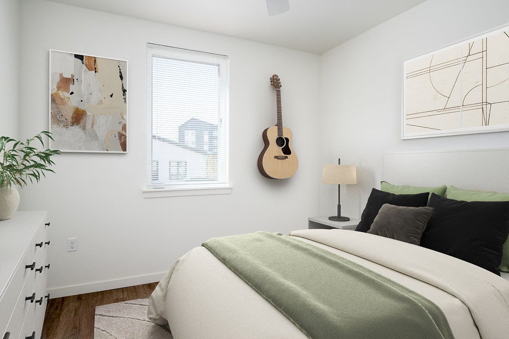 a bedroom with a bed and a guitar on the wall