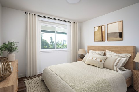 A bedroom with a large bed and a window with curtains.