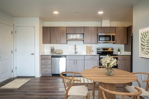 a kitchen and dining room with a wooden table and chairs