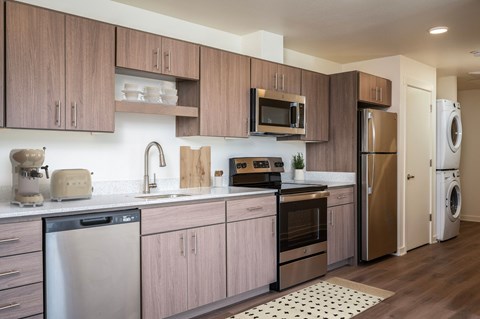 A modern kitchen with wooden cabinets and stainless steel appliances.