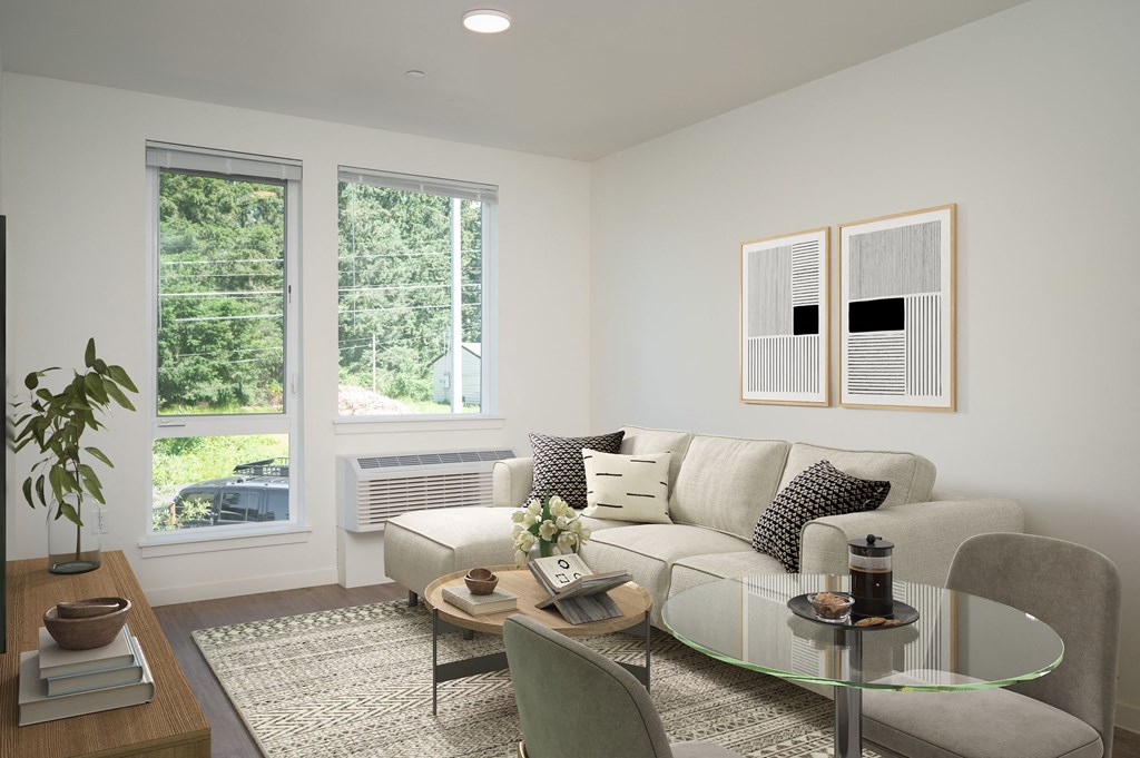 a living room with a couch and a table and three windows