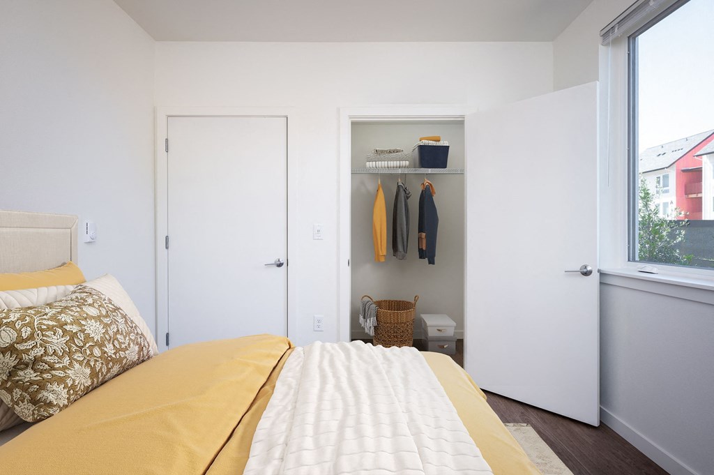 a bedroom with a bed and a closet and a window