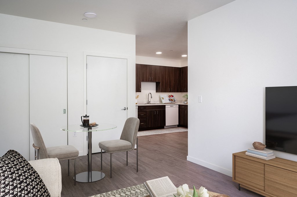 a living room and kitchen with a table and chairs