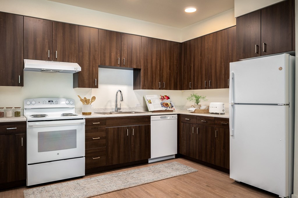 a kitchen with white appliances and dark wood cabinets