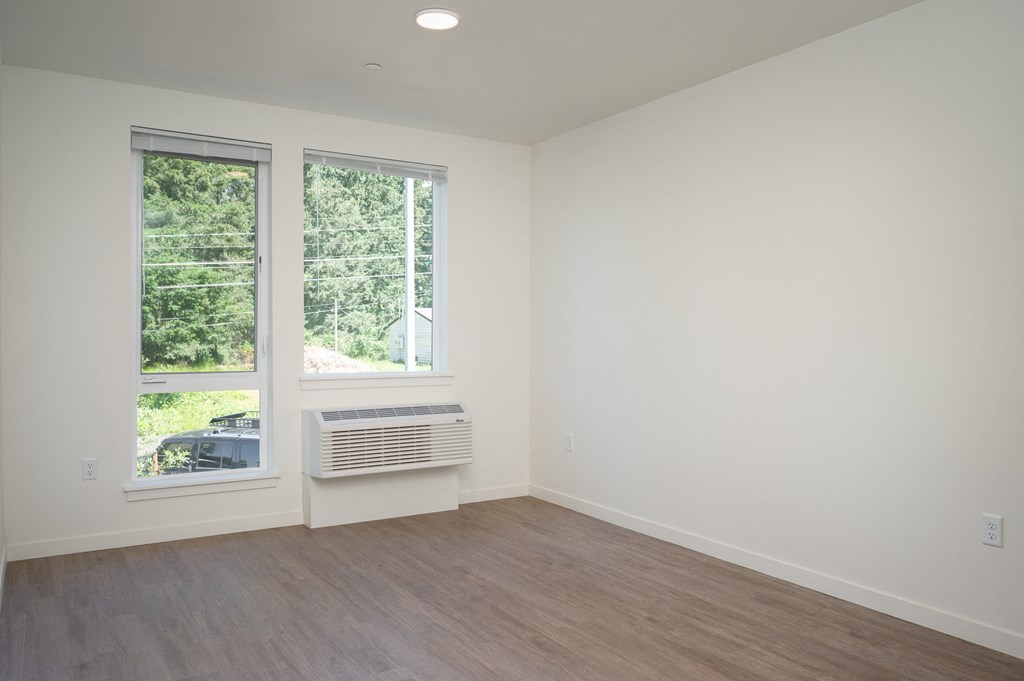 an empty room with white walls and a window
