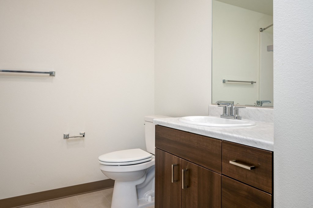 an empty bathroom with a toilet sink and mirror