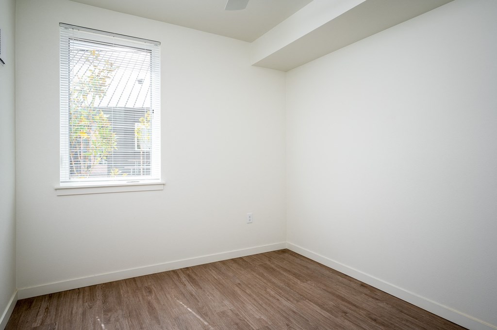 an empty room with white walls and a window