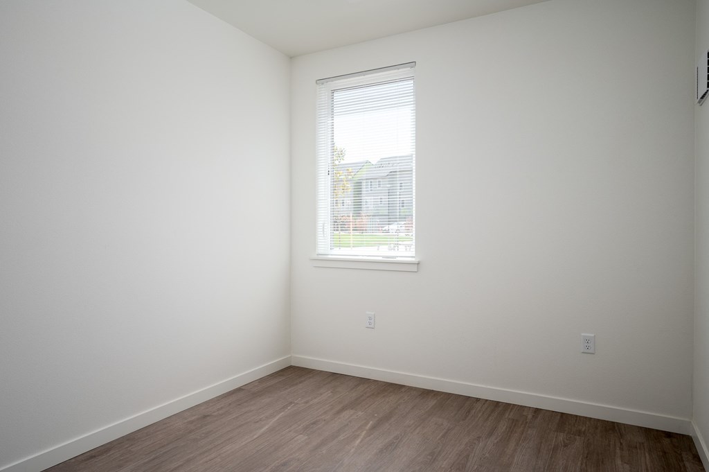 an empty room with white walls and a window