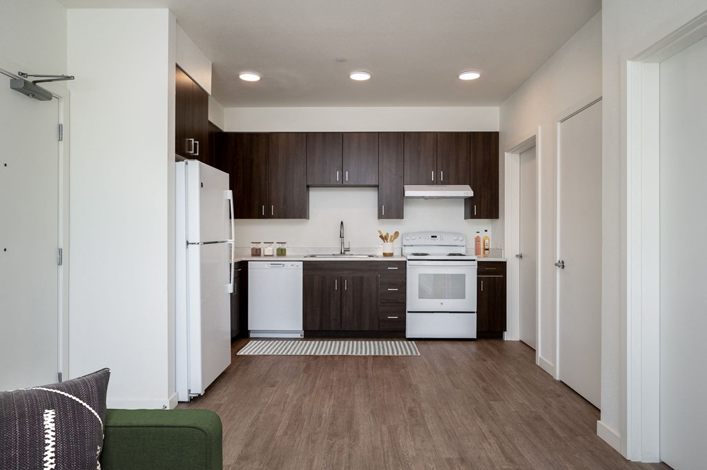 a kitchen with white appliances and dark wood cabinets