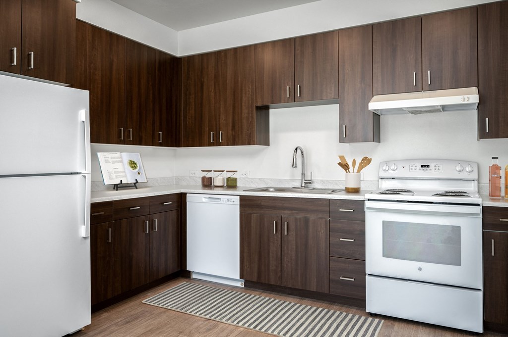 a kitchen with white appliances and wooden cabinets