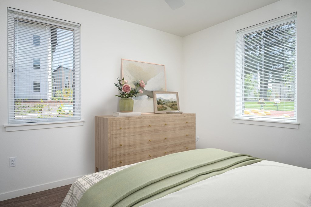 a bedroom with a bed and two windows