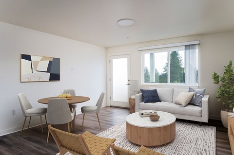 A living room with a white couch, a round wooden coffee table, and a painting on the wall.