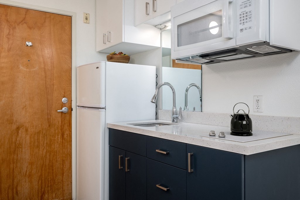 a kitchen with a sink and a refrigerator and a door
